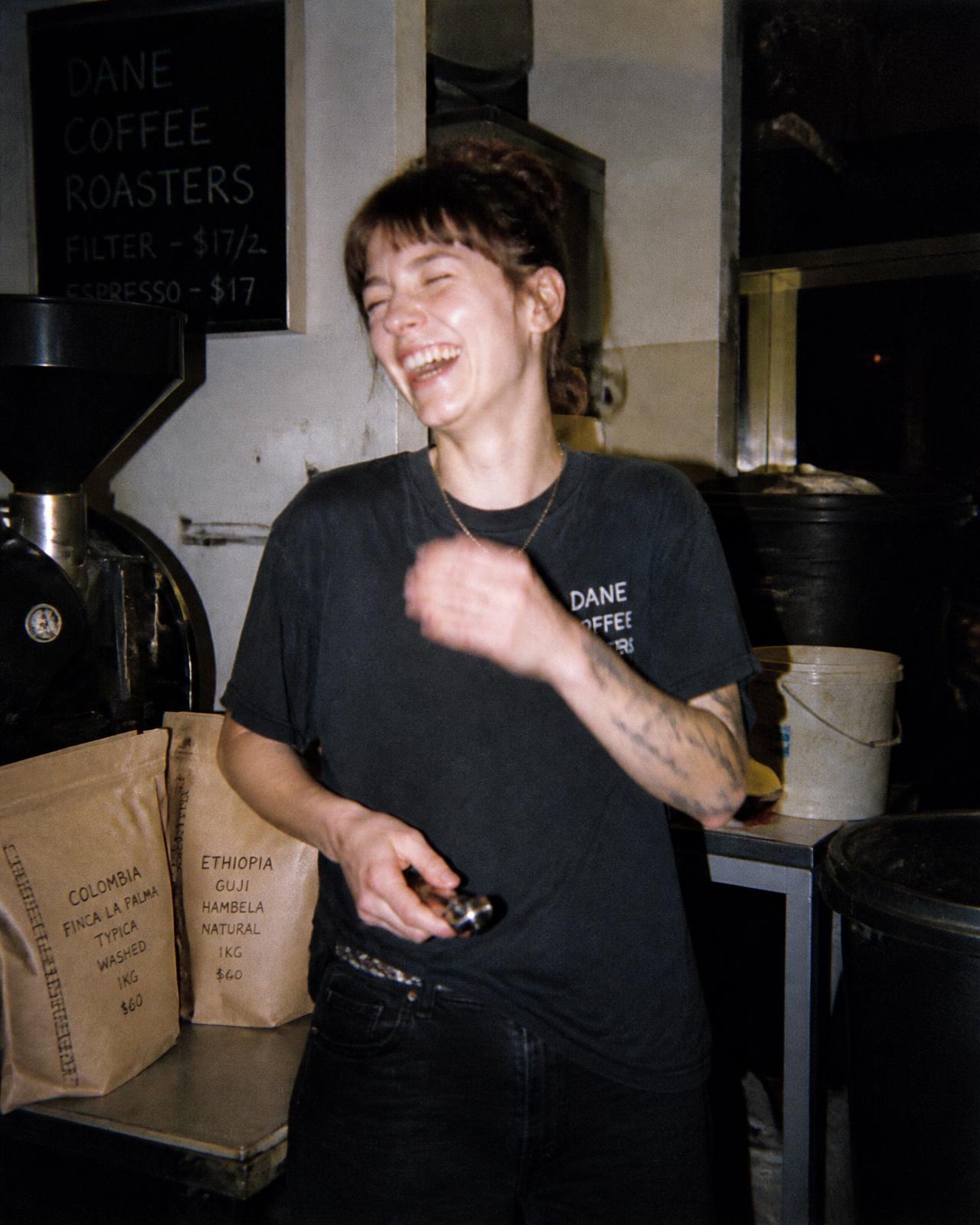 A roaster laughing mid-shift, captured with direct flash